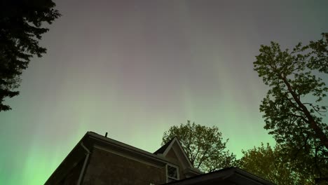 Aurora-Boreal-Bailando-Sobre-Una-Casa-Y-árboles,-Timelapse