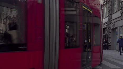 Public-transport,-busses-and-trams,-and-pedestrians-on-Anichstrasse-street-in-the-city-center-of-Innsbruck,-Tyrol,-Innsbruck