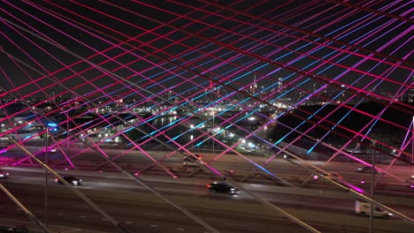 An-aerial-view-of-the-illuminated-cables-and-concrete-towers-of-the-Kosciuszko-Bridge,-lit-up-by-light-emitting-diodes