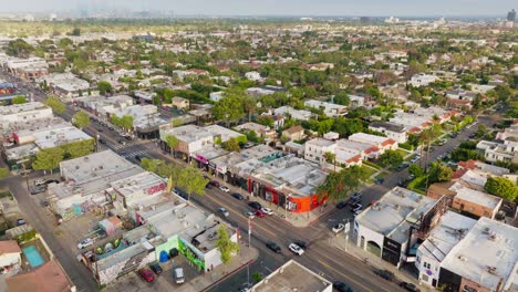 Drone-Shot-Over-Vibrantly-Colored-Shops-on-Melrose-Avenue-in-West-Hollywood,-Bright-Walls-and-Busy-Streets-on-Sunny-Day