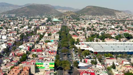 Dolly-in-establishing-flyover-of-the-paved-Guadalupe-Causeway-with-a-pilgrimage-to-the-Basilica-of-Guadalupe,-in-Mexico-City-on-a-sunny-day