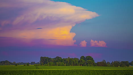 Colorful-cumulonimbus-clouds-at-sunset-over-farmland-fields---time-lapse