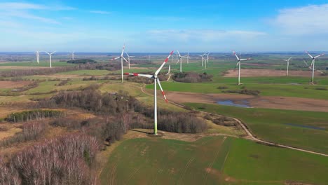 drone-footage-of-wind-turbines-in-a-wind-farm-generating-green-electric-energy-on-a-wide-green-field-on-a-sunny-day,-in-Taurage,-Lithuania