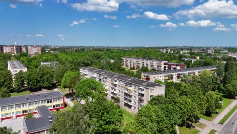 Old,-unrenovated-buildings-surrounded-by-greenery-in-klaipeda,-aerial-view