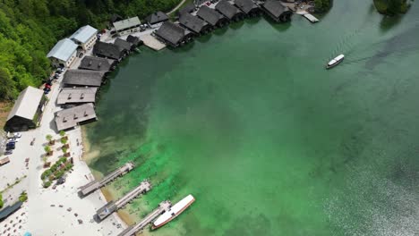 Aerial-view-of-electric-tourist-boat-arriving-to-the-small-harbor-at-Schönau-on-picturesque-lake-Königssee-near-the-town-of-Berchtesgaden-in-the-Bavarian-Alps-in-Germany