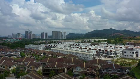 Aerial-views,-drone-flyover-Taman-Jelok-Impian,-reveal-Semanja-Kajang-project,-a-residential-neighborhood-featuring-rows-of-semi-detached-houses-under-construction-against-mountain-landscape