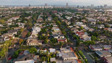 Aerial-Drone-Shot-of-West-Hollywood-Neighborhood-in-Daytime,-Buildings-on-Horizon-and-Trees-and-Rooftops-Below