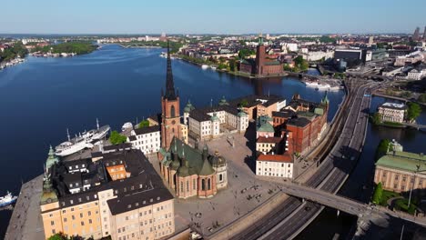 Luftaufnahme-Eines-Booms-über-Der-Riddarholmen-Kirche,-Dem-Stockholmer-Rathaus-Im-Hintergrund