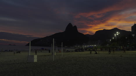 Menschen-Gehen-Spazieren,-Entspannen-Und-Spielen-Bei-Sonnenuntergang-Am-Strand-Von-Ipanema