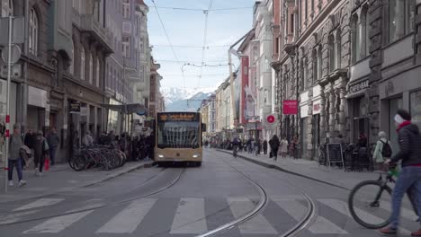 Public-transport,-busses-and-trams,-and-pedestrians-on-Anichstrasse-street-in-the-city-center-of-Innsbruck,-Tyrol,-Innsbruck