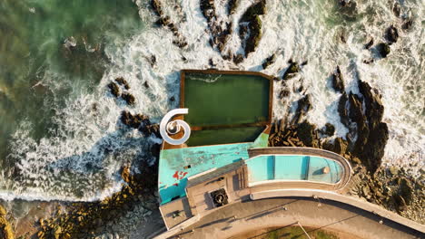 Top-down-drone-shot-above-a-waterslide-and-pool-on-the-coast-of-Mazatlan,-Mexico