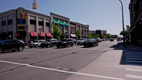 Downtown-Dearborn,-Michigan-intersection-with-traffic-driving-by-and-stable-video