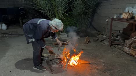 La-Gente-Local-Intenta-Hacer-Fuego-De-Leña-Para-Asar-Pollo-A-La-Parrilla-En-Una-Aldea-Rural,-En-El-Campo,-En-El-Desierto,-En-El-Patio-Trasero-De-La-Casa,-Reuniéndose-Por-La-Noche-En-El-Medio-Oriente-Dentro-De-La-Casa-Privada,-Cocina-Tradicional.