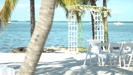 Schöne-Aufnahme-Von-Dekoration-Und-Blumen-Am-Hochzeitsort,-Sitzgelegenheiten-Im-Freien,-Sitzgelegenheiten-Am-Sandstrand-Mit-Tischen