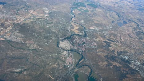 Aerial-spinning-view-of-Toledo-city-and-Tagus-river-shot-from-an-airplane-cockpit-flying-at-3000m-high