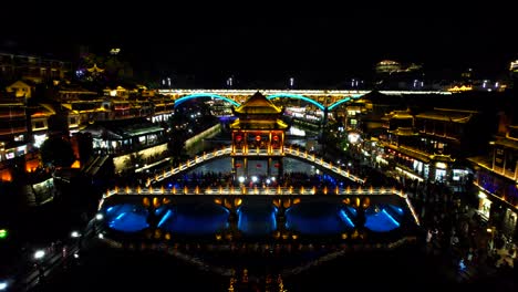 Beleuchtete-Schneebrücke-Und-Nanhua-Brücke-über-Tuo-Jiang-In-Der-Altstadt-Von-Fenghuang,-China