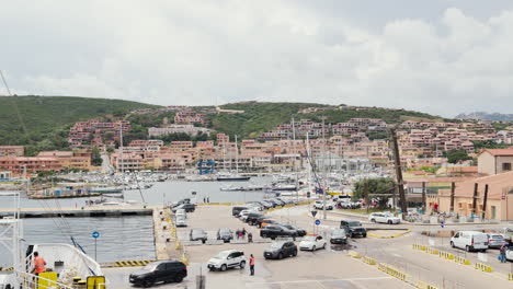 Bustling-Sardinian-port-with-boats-and-hillside-buildings