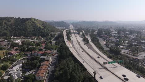 Los-Angeles,-California-freeway-on-a-smoggy,-hazy-day---rising-aerial-reveal