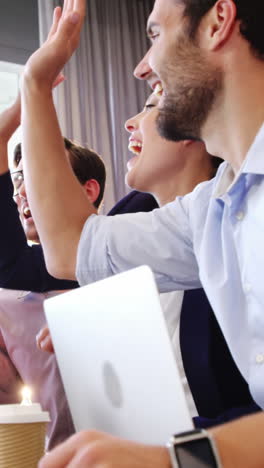 Businesspeople-interacting-and-giving-high-five-to-each-other