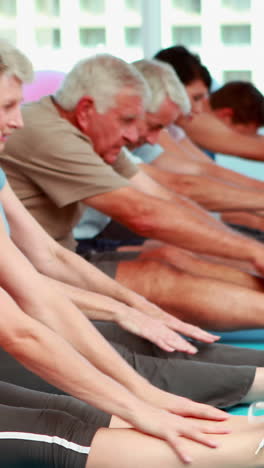 Exercise-class-stretching-and-touching-their-toes