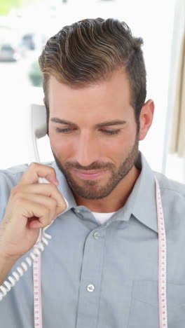 Handsome-fashion-designer-working-at-his-desk-