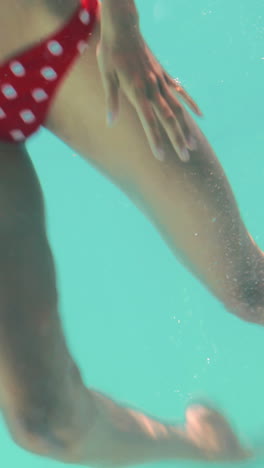 Smiling-woman-swimming-underwater