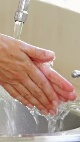 Woman-washing-her-hands-at-the-sink