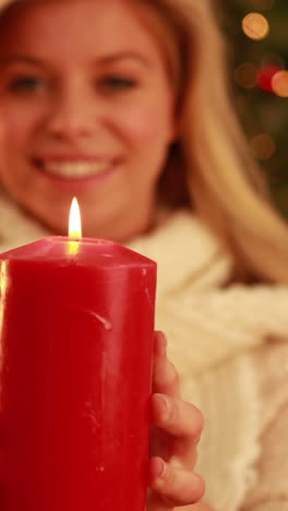 Pretty-blonde-holding-candle-at-christmas