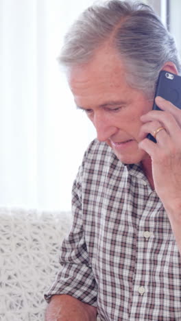 Focused-elderly-couple-calling-doctor