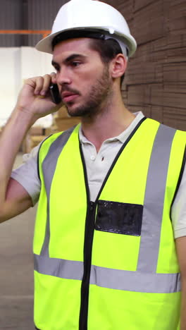 Warehouse-worker-talking-on-the-phone-looking-around