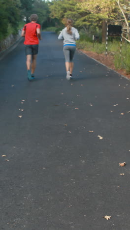 Pareja-Corriendo-En-La-Carretera-Abierta