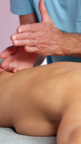 Männlicher-Physiotherapeut,-Der-Einer-Patientin-Eine-Rückenmassage-Gibt