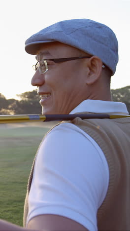 Golfer-carrying-golf-club-over-shoulder-while-standing-on-the-golf-course