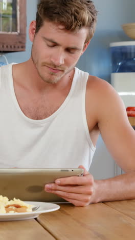 Man-using-tablet-in-kitchen