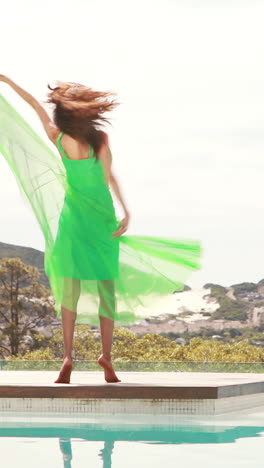 Joven-Mujer-Feliz-Bailando-Junto-A-La-Piscina