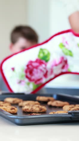 Padre-Sacando-Galletas-Calientes-Del-Horno-Con-Un-Niño-Oliéndolas