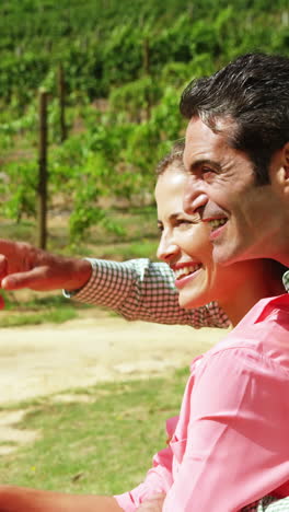 Happy-couple-interacting-while-sitting-in-field