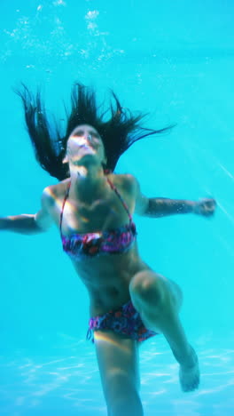 Pretty-brunette-swimming-underwater-in-pool