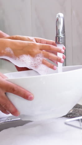 Close-up-father-and-daughter-doing-the-dishes-