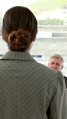 Happy-business-people-looking-at-camera-during-presentation-