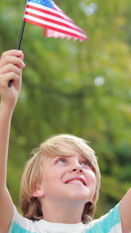 Little-boy-waving-american-flag-in-the-park