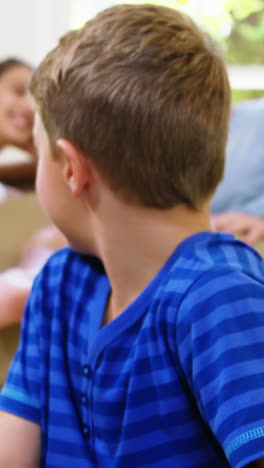 Kid-playing-in-front-of-the-camera-with-parents-behind