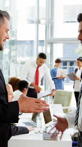 Businessmen-shaking-hands-in-office