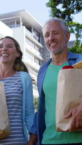 Pareja-Madura-Está-Sonriendo-Y-Caminando-Con-Comestibles