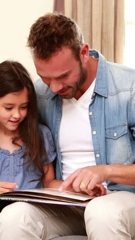 Happy-father-and-daughter-reading-a-book