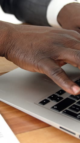 Businessman-using-laptop-at-his-desk