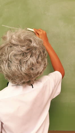 Cute-pupil-writing-maths-on-chalkboard