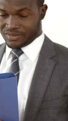 Portrait-of-businessman-smiling-and-holding-a-file