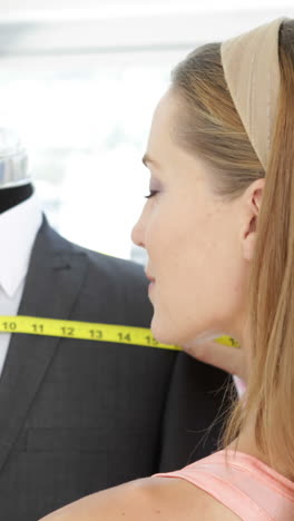 Attractive-fashion-designer-measuring-suit-on-mannequin