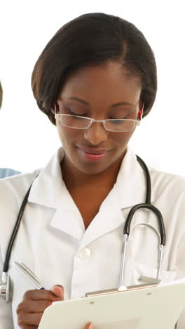 Nurse-going-over-a-file-and-smiling-at-colleague